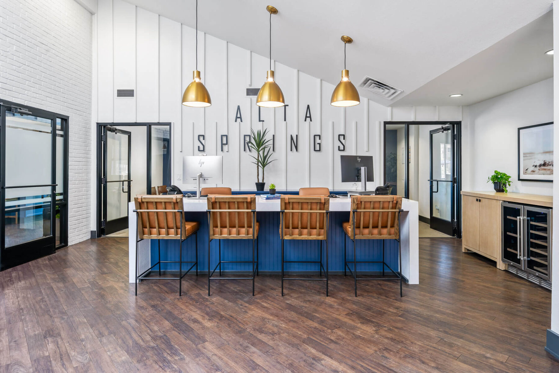 Reception space with four bar stools and two computers on top of overhang bar counter.